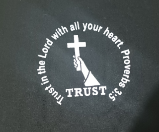 trust in the lord with all your heart. proverbs 3:5 circling the hand holding the cross with the word trust below the hand.
