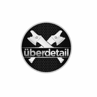 the mark consists of a circular emblem containing two crossed dual-action polishing machines at the center, with stylized text forming the word “Überdetail” across the middle. the design includes a geometric honeycomb background texture within the circle 